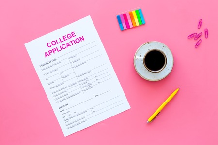 Higher education. College application form ready to fill near coffee cup and stationery on pink background top view.の写真素材