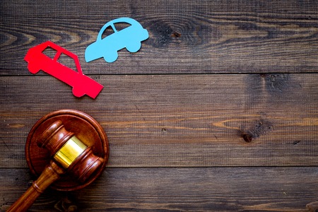 Car accident lawsuit concept. Two collided cars near judge gavel on dark wooden background top view copy spaceの写真素材