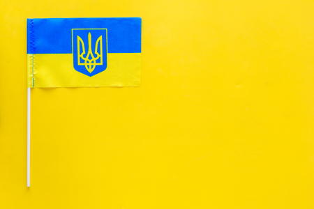 Ukrainian flag concept. small flag on yellow background top view copy spaceの写真素材
