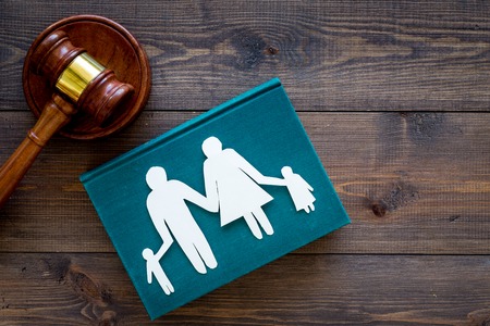 Family law, family right concept. Child-custody concept. Family with children cutout near court gavel on dark wooden background top view copy space