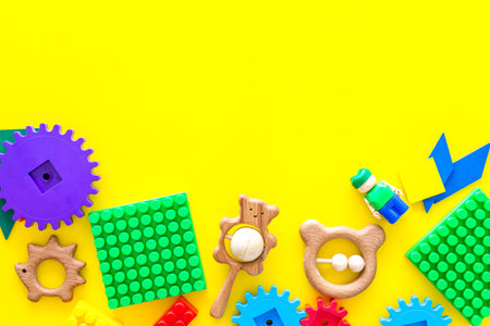 Developing children games mockup. Colorful plastic bricks and blocks on yellow background top view.の写真素材