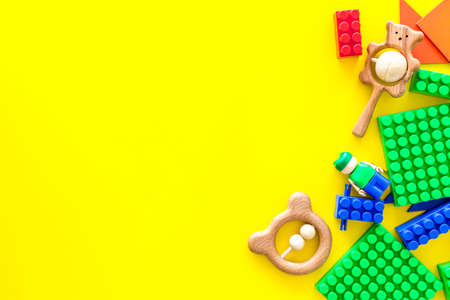 Developing children games mockup. Colorful plastic bricks and blocks on yellow background top view.の写真素材