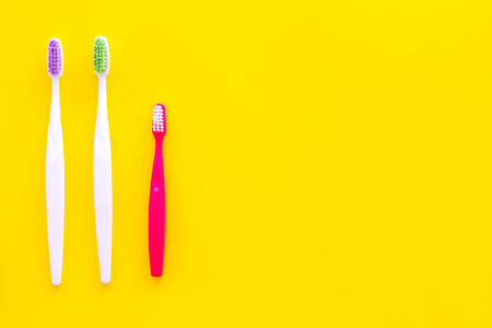 Oral hygeine. Toothbrushes on yellow background top view copy spaceの写真素材