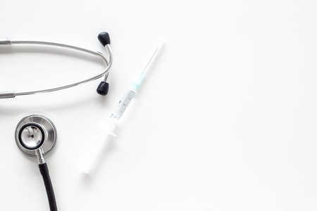 Infuenza vaccine in syringe near stethoscope on white background top view.の写真素材
