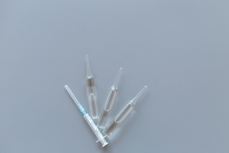 Flu vaccination concept. Syringe and ampoulie on grey background top view.の写真素材