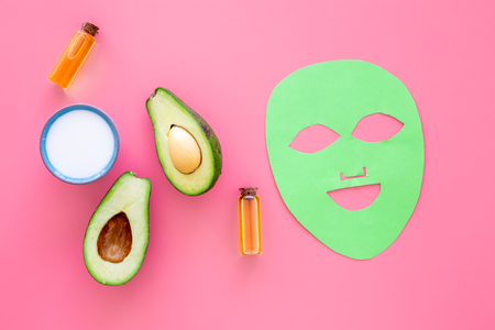 Skin care. Facial mask, cream and lotion with avocado essential oil on pink background top viewの写真素材