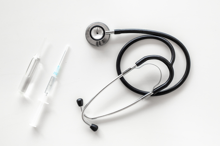 Infuenza vaccine in syringe near stethoscope on white background top view.の写真素材
