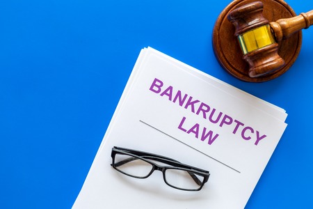 Words bankruptcy law written on the documents near judge gavel on blue background top view copy spaceの写真素材
