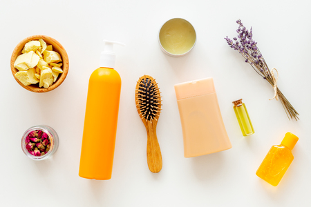 Cosmetics for hair care with jojoba, argan or coconut oil. Bottles and pieces of oil on white background top viewの写真素材