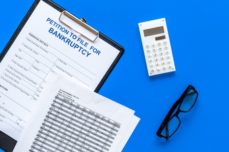 Petition to file for bankruptcy. Empty form ready to fill near calculator on blue background top viewの写真素材