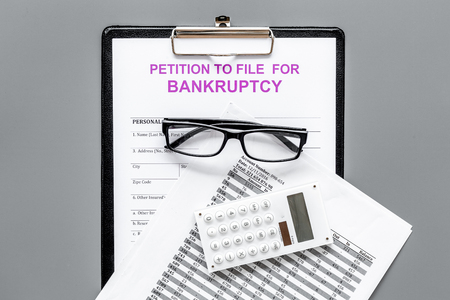 Petition to file for bankruptcy. Empty form ready to fill near calculator on grey background top viewの写真素材