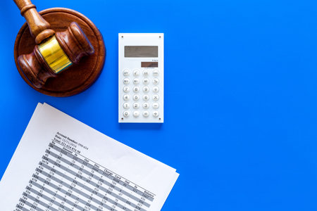 Declare bankruptcy concept. Judge gavel, financial documents, calculator on blue background top view...