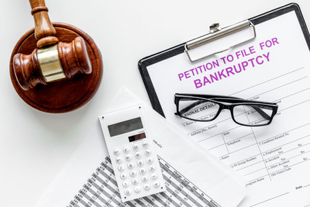 Petition to file for bankruptcy. Empty form ready to fill near calculator and judge gavel on white...