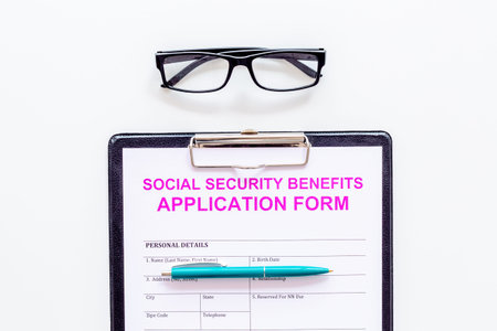 Social security benefits. Application form near pen and glasses on white background top view