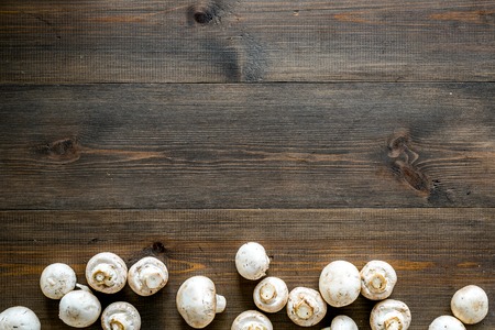Mushroom champignons. Fresh raw whole champignons on dark wooden background top view.の写真素材