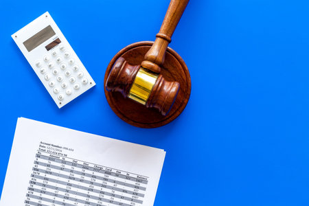 Declare bankruptcy concept. Judge gavel, financial documents, calculator on blue background top view...