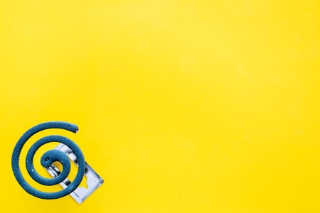 Mosquito repellent for outdoor: garden, summer house, picnic. Green spiral on yellow background top view copy spaceの写真素材