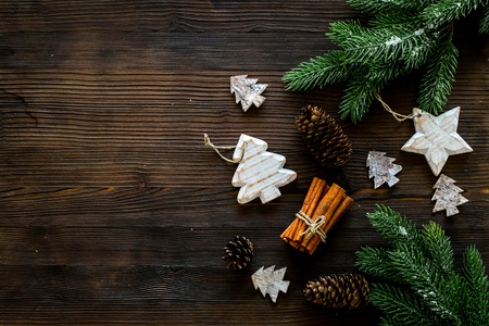 Christmas background. Spruce branch, cones and toys for decoration on dark wooden background top view copy spaceの写真素材