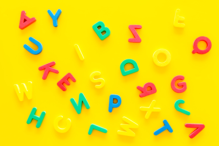 Alphabet for kids concept. English letters in disorder on yellow background top view.の写真素材