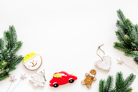 Set of New Year festive ginferbread cookies in shape of gingerbread man, new year spruce, snowman, heart near cinnamon and spruce branch on white background top view.の写真素材