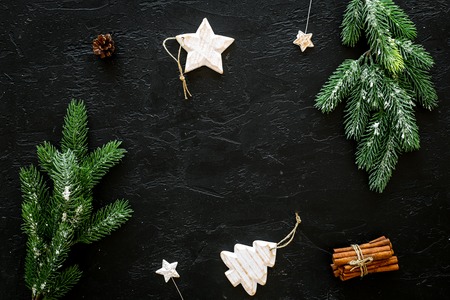 Decoration for winter holidays concept. Christmas, New year. Spruce branch, cones and toys on black background top view.の写真素材