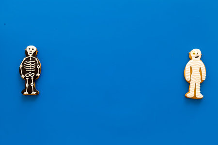 Halloween traditions. Halloween gingerbread in shape of evil characters on blue background top view.