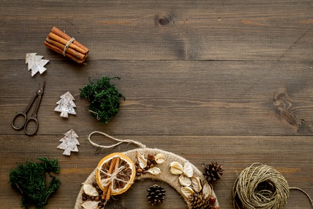 Christmas decoration concept. Creative Christmas wreath made of thread near materials and instruments, scissors on dark wooden background top view.の写真素材