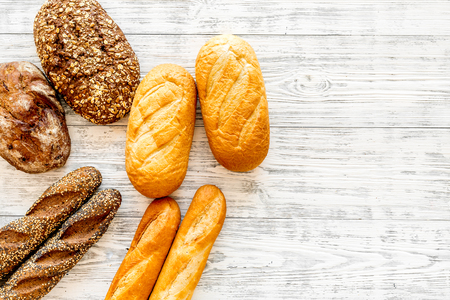 Fresh rustic homemade bread on white wooden background top view copy spaceの写真素材