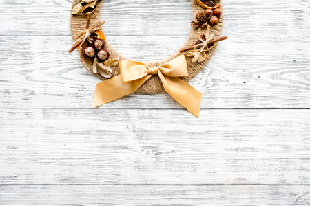 Creative, unusual christmas wreath made of thread, dry fruits and nuts on white wooden background top view.の写真素材
