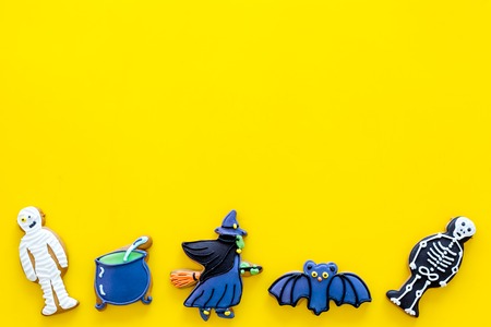 Halloween traditions. Halloween gingerbread in shape of evil characters on yellow background top view space for textの写真素材