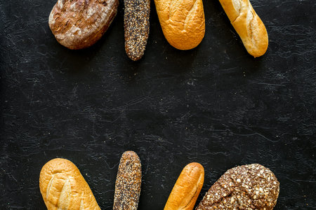 Set of fresh homemade bread. Bread assortment. Loaf, baguette. White and brown bread on black...