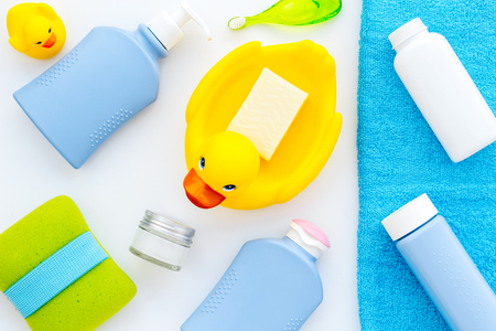 Shower accessories for child. Set with shampoo, towel, soap, gel, towel, brush and yellow rubber duck on white background top view.の写真素材