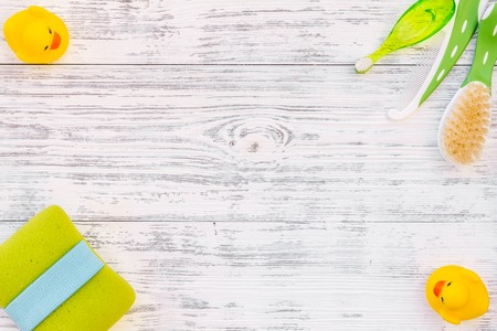 Hygiene items for the child. Bath accessories with yellow rubber duck on light grey wooden background top view.の写真素材