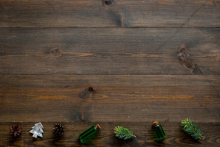 Winter ornament, New Year pattern. Pine sprigs, cones, spruce figure, fir oil on dark wooden background top view.の写真素材