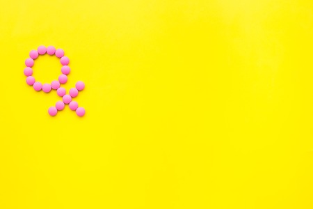 Female diseases. Female gender icon symbol made of pills on yellow background top view.の写真素材