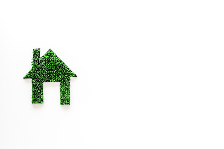 Green eco energy concept. House silhouette made of green grass on white background top view copy spaceの写真素材
