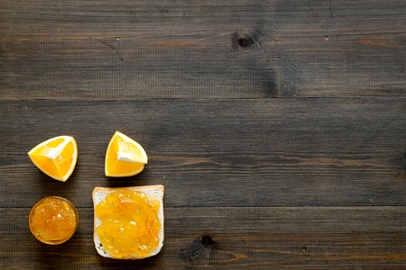 Sweet breakfast. Toast with orange jam on dark wooden background top view.の写真素材