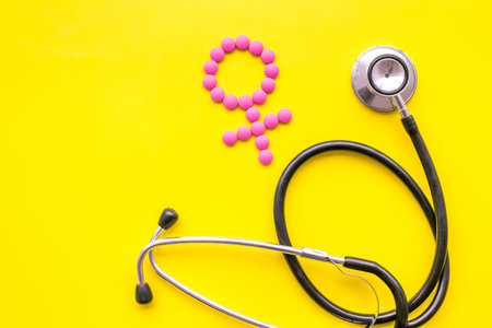 Female diseases concept. Stethoscope near female sign on yellow background top view copy space
