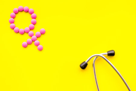 Female diseases concept. Stethoscope near female sign on yellow background top view.の写真素材