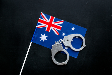 Violation of law, law-breaking concept. Metal handcuffs on Australian flag top view.の写真素材