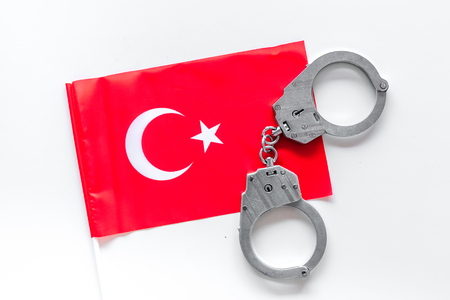 Violation of law, law-breaking concept. Metal handcuffs on Turkish flag on white background top viewの写真素材