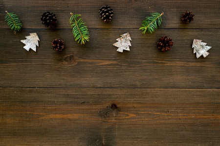 Winter ornament, New Year pattern. Pine sprigs, cones, spruce figure, fir oil on dark wooden background top view space for textの写真素材