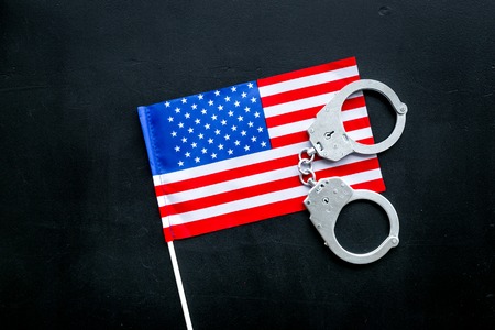 Violation of law, law-breaking concept. Metal handcuffs on American, USA flag top view.の写真素材