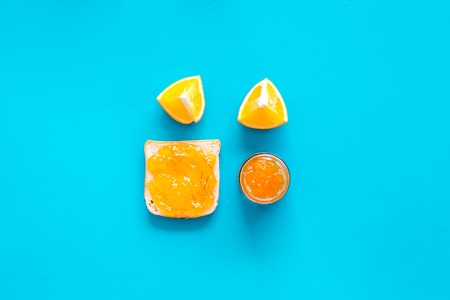Sweet breakfast. Toast with orange jam on blue background top view copy spaceの写真素材