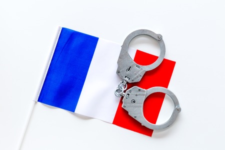 Violation of law, law-breaking concept. Metal handcuffs on French flag on white background top viewの写真素材