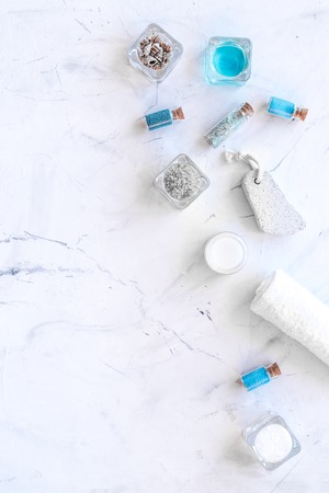 Dead sea cosmetics layout. Sea salt in bottles and bowls near small shells on white stone background top view copy spaceの写真素材