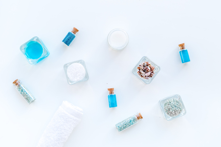 Dead sea cosmetics layout. Sea salt in bottles and bowls near small shells on white background top viewの写真素材