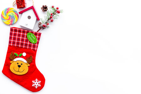 Christmas gift concept, christmas surprises. Traditional festive socks filled with gift box, sweets, winter decor on white background top view copy spaceの写真素材