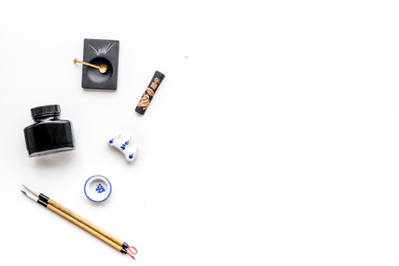 Accessories for Chinese or Japanese calligraphy. Special writing pen, ink on white background top view copy spaceの写真素材