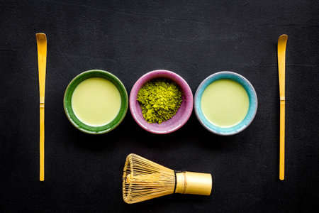Brew matcha green tea. Matcha powder, ready matcha tea, whisk on black background top viewの写真素材